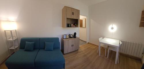 - un salon avec un canapé bleu et un bureau dans l'établissement Studio Paris Clichy, à Clichy