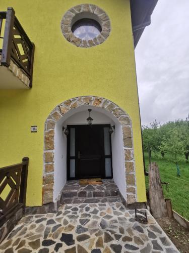 a yellow building with a round window and a door at Yellow House in Bran