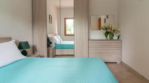 ポルト・オッティオルにあるCasa Ficusのベッドルーム(青いベッド1台、鏡付)