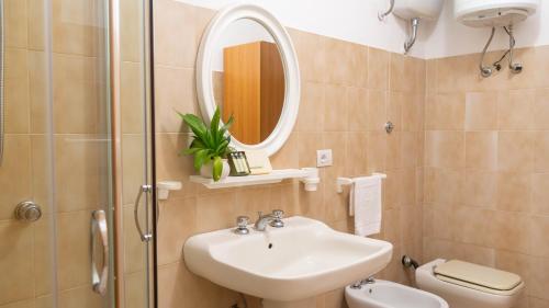 uma casa de banho com um lavatório, um WC e um espelho. em Casa Ficus em Porto Ottiolu