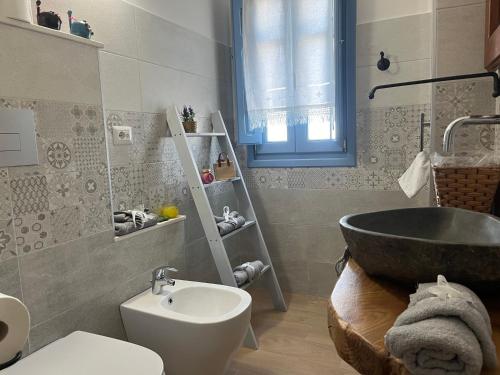 a bathroom with a tub and a toilet and a sink at Attico BELLAVISTA in Baunei