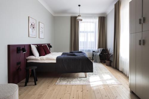 a white bedroom with a bed and a window at Centra Nams - Center Apartments in Cēsis