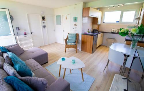 a living room with a couch and a table and a kitchen at K145 The Retreat at Camber Sands in Camber