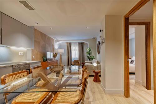 eine Küche und ein Wohnzimmer mit einem Glastisch und Stühlen in der Unterkunft Bernabeu Place en Madrid in Madrid