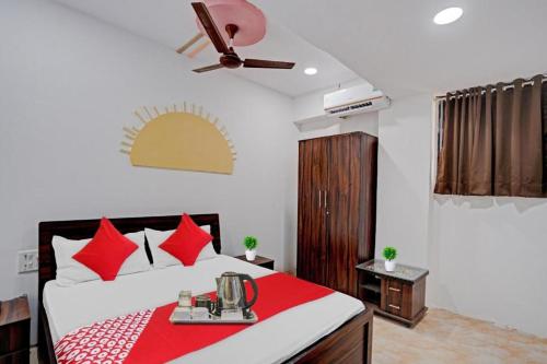 Hotel Terrace Inn في سورات: غرفة نوم بسرير ومخدات حمراء