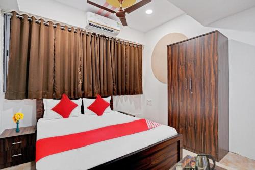 Hotel Terrace Inn في سورات: غرفة نوم بسرير كبير ومخدات حمراء