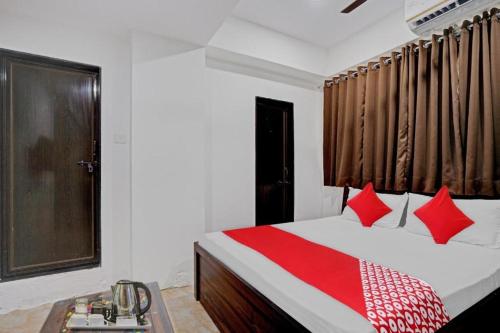 um quarto com uma cama com almofadas vermelhas e uma janela em Hotel Terrace Inn em Surat