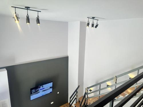 a living room with a wall mounted tv and stairs at Piraeus Point I in Piraeus