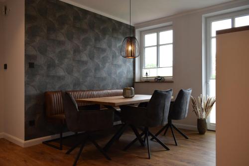 DZ/EZ Lodberger Scheunencafe في Löningen: غرفة طعام مع طاولة وكراسي خشبية