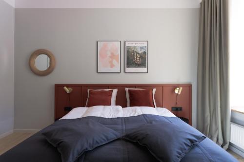 a bedroom with a bed with blue and white sheets at Centra Nams - Center Apartments in Cēsis