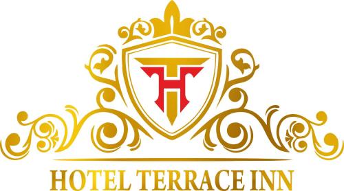 un bouclier avec une lettre t et une couronne dans l'établissement Hotel Terrace Inn, à Surate