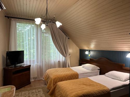 a bedroom with two beds and a tv and a window at LETIZIA country club in Shaian