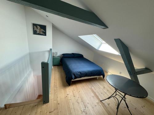 a bedroom with a bed and a chair in a attic at Clos Margot in Le Mans