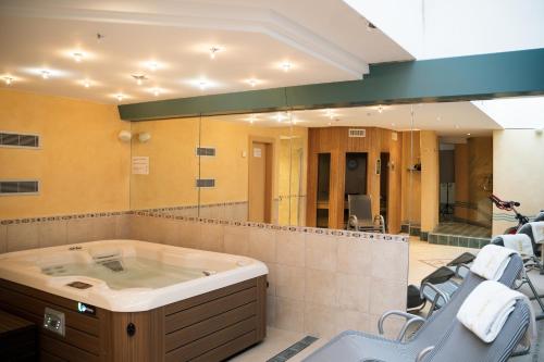 a large bathroom with a tub and a group of chairs at Haus Shangri-La in Saas-Fee