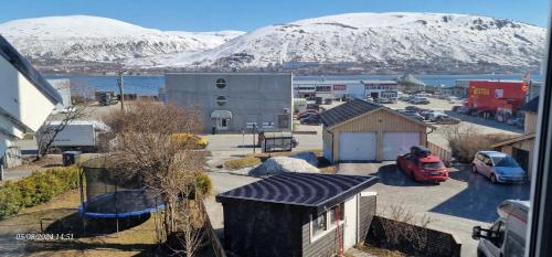 una piccola cittadina con una montagna innevata sullo sfondo di Northern Lights Apartment a Tromsø