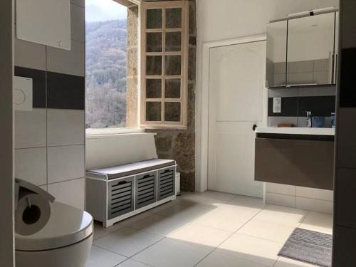une salle de bain avec un lavabo et une fenêtre et des toilettes dans l'établissement Le Chevalier - Maison et jardin face à la montagne, à Saint-Vincent