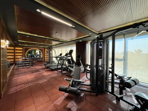 a gym with a row of treadmills and machines at Ankawa Holiday Hotel in Erbil