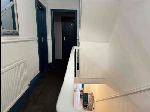 baño con lavabo blanco y escalera en Comfortable Room in Shared Sheffield Detached House - Room 3, en Neepsend