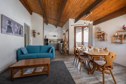 Echo des marmottes - Terrasse - Barbecue - Parking في Enchastrayes: غرفة معيشة مع أريكة زرقاء وطاولة