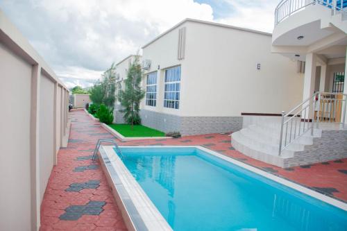 uma casa com piscina ao lado de um edifício em Ladari Apartments em Babati