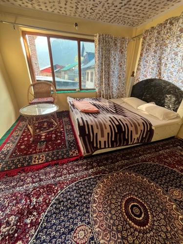 a bedroom with a bed and a window and a rug at Pine Brooke Pahalgam in Pahalgām
