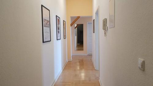 a hallway with several pictures on the walls and a hallway with a hallway at Kienreich Apartments Görlitzer Innenstadt in Görlitz