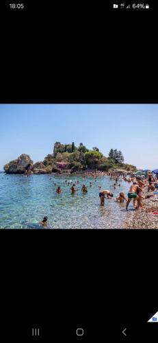 a group of people in the water at a beach at Borgo Marino casa vacanze in Santa Teresa di Riva