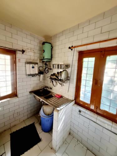 a kitchen with a sink and a stove in it at Snow land cottage in Manāli