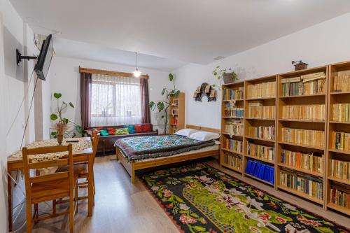 una habitación con una cama y estanterías en La Curtea Porumbaceana, en Porumbacu de Sus