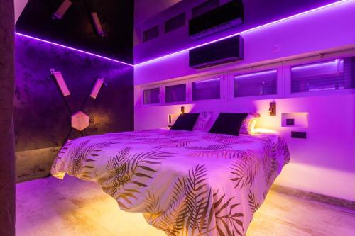 une chambre avec un éclairage violet et un lit dedans dans l'établissement Gin Fizz Port Nature, au Cap d'Agde