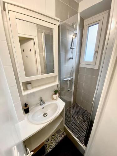 une salle de bain blanche avec un lavabo et une douche dans l'établissement Calme Wifi Fibre Netflix Gare à pied, à Corbeil-Essonnes