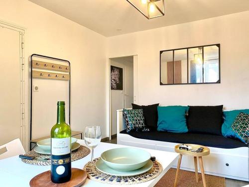 - un salon avec un canapé et une table avec une bouteille de vin dans l'établissement Calme Wifi Fibre Netflix Gare à pied, à Corbeil-Essonnes