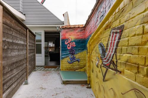 a wall with graffiti on it next to a house at Huswell - Cosy two bedroom apartment in Middelkerke in Middelkerke