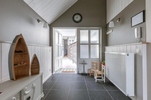 a hallway of a house with a clock on the wall at Huswell - Cosy two bedroom apartment in Middelkerke in Middelkerke