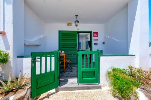 une porte verte menant à un bâtiment avec une table dans l'établissement Casa Emilia-close to amenities and the beach, à Puerto del Carmen