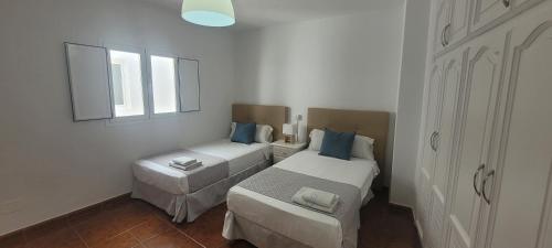 a small bedroom with two beds and a window at Sabbia Suites Casa San Miguel in Teguise