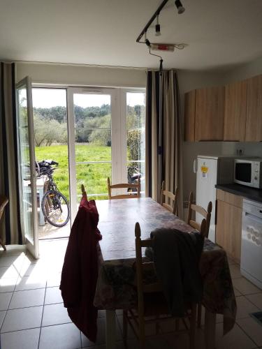 une cuisine avec une table et des chaises ainsi qu'une fenêtre dans l'établissement Pomme, à Talmont-Saint-Hilaire