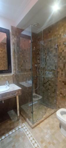 a bathroom with a glass shower and a sink at Les Jardins de la palmeraie in Marrakech