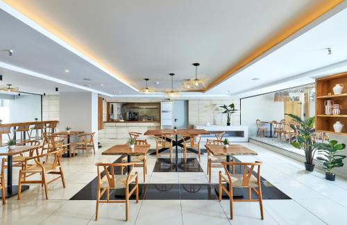 a dining room with wooden tables and chairs at Lotus Rise Hotel - Adults Only in Hersonissos