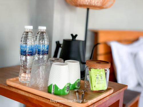 uma mesa com garrafas de água e toalhas de papel em Happiness Long Bridge Resort 