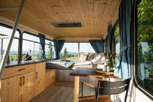 a kitchen and dining area of an rv with a bed at Bus Ikarus in Prievidza