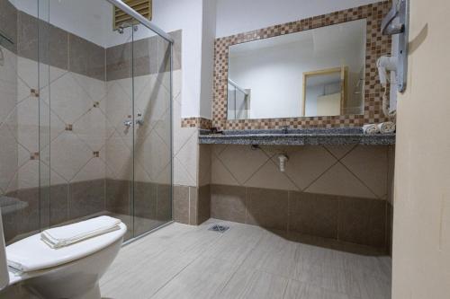 a bathroom with a toilet and a shower and a mirror at ARAGUAIA HOTEL in Barra do Garças