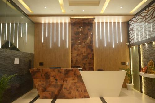 vestíbulo con pared de madera y silla blanca en Hotel The Plateau, en Ranchi