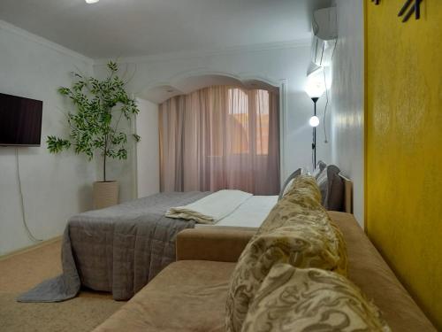 a bedroom with two beds and a potted plant at ЯРКАЯ ЗВЕЗДА НА КОСМОСЕ ! in Aktobe