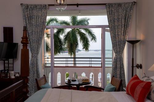 a bedroom with a bed and a view of the ocean at Brunton Boatyard - CGH Earth in Cochin