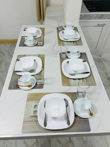 a table with white plates and glasses on it at 93 House in Ban Bang Toei (1)