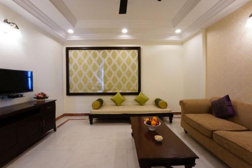 a living room with a couch and a tv at Shree Vallabh Vilas Lords Plaza Nathdwara - Pure Veg in Eklingji