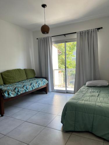 Schlafzimmer mit einem Bett und einer Glasschiebetür in der Unterkunft Dos ambientes San Justo in San Justo