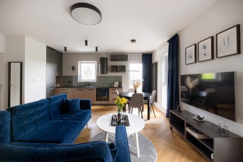 a living room with a blue couch and a table at UNIQUE Apartment with parking in Toruń