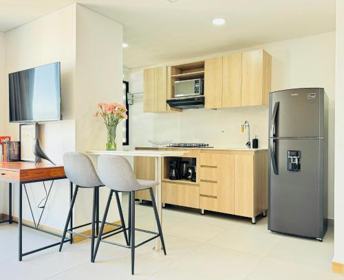 a kitchen with a refrigerator and a table and chairs at Loft luminoso y moderno con excelentes vistas in Medellín